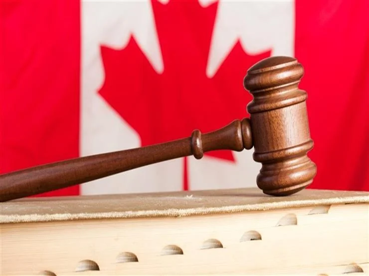 مطرقة محكمة على طاولى والخلفية عبارة عن العلم الكندي