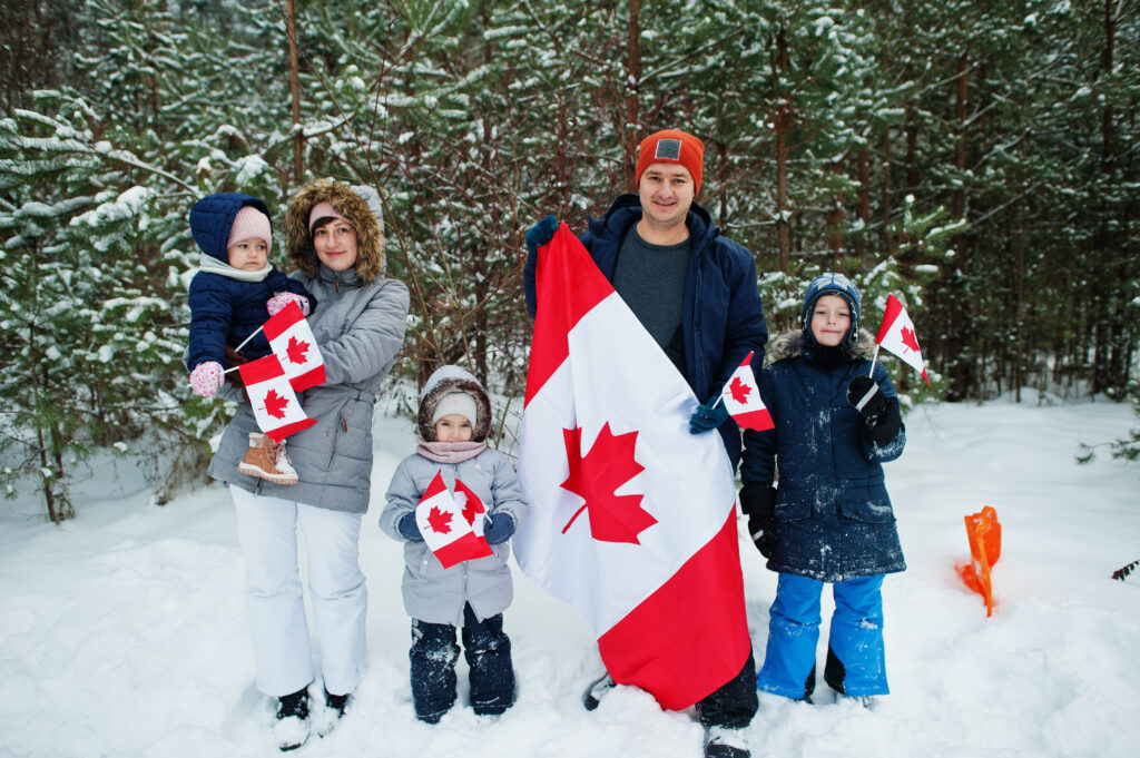 عائلة ترفع العلم الكندي إحتفالاً بالجنسية الكندية في فصل الشتاء