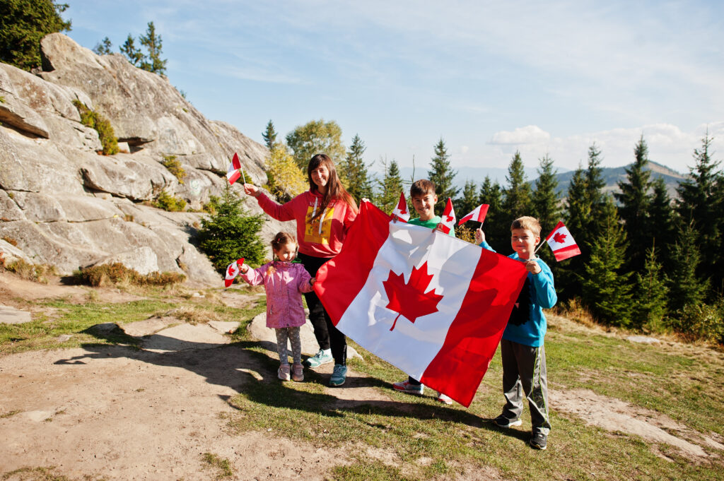 عائلة ترفع العلم الكندي إحتفالاً بالجنسية على أحد الجبال في الأراضي الكندية 