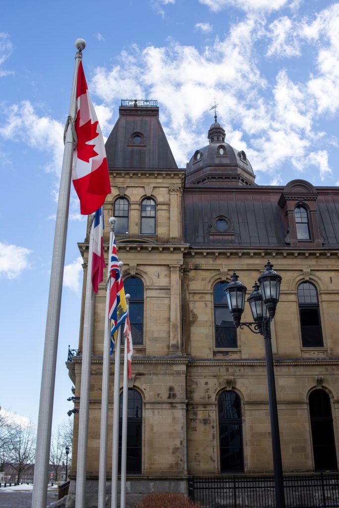 الجمعية التشريعية لنيو برونزويك في فريدريكتون نيو برونزويك مع علم كندا.