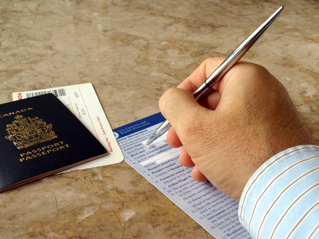 شخص يملأ نموذج الطلب من أجل الحصول على جواز السفر الكندي بعد اجتياز امتحان الجنسية الكندية.