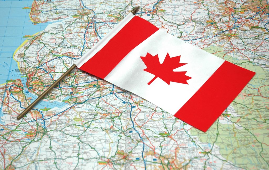 العلم الكندي موضوع فوق خريطة طريق العالم.