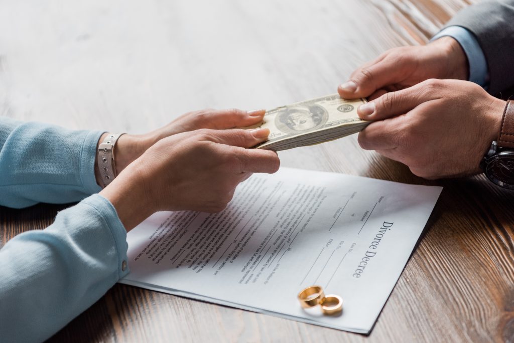 المحامي والموكل يحملان الأوراق النقدية بالدولار فوق قرار الطلاق مع خواتم الزفاف
