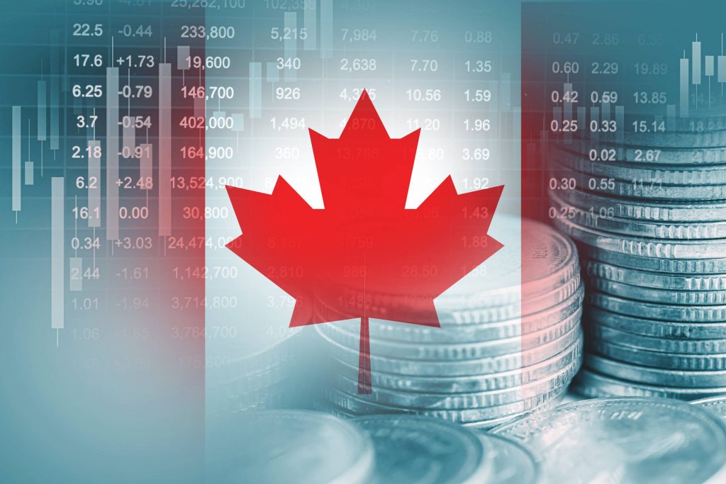 ورق القيقب الكندي موضوع في المقدمة وفي الخلفية مجموعة من العملات المعدنية، يرمز إلى الاقتصاد أو السوق المالية في كندا.