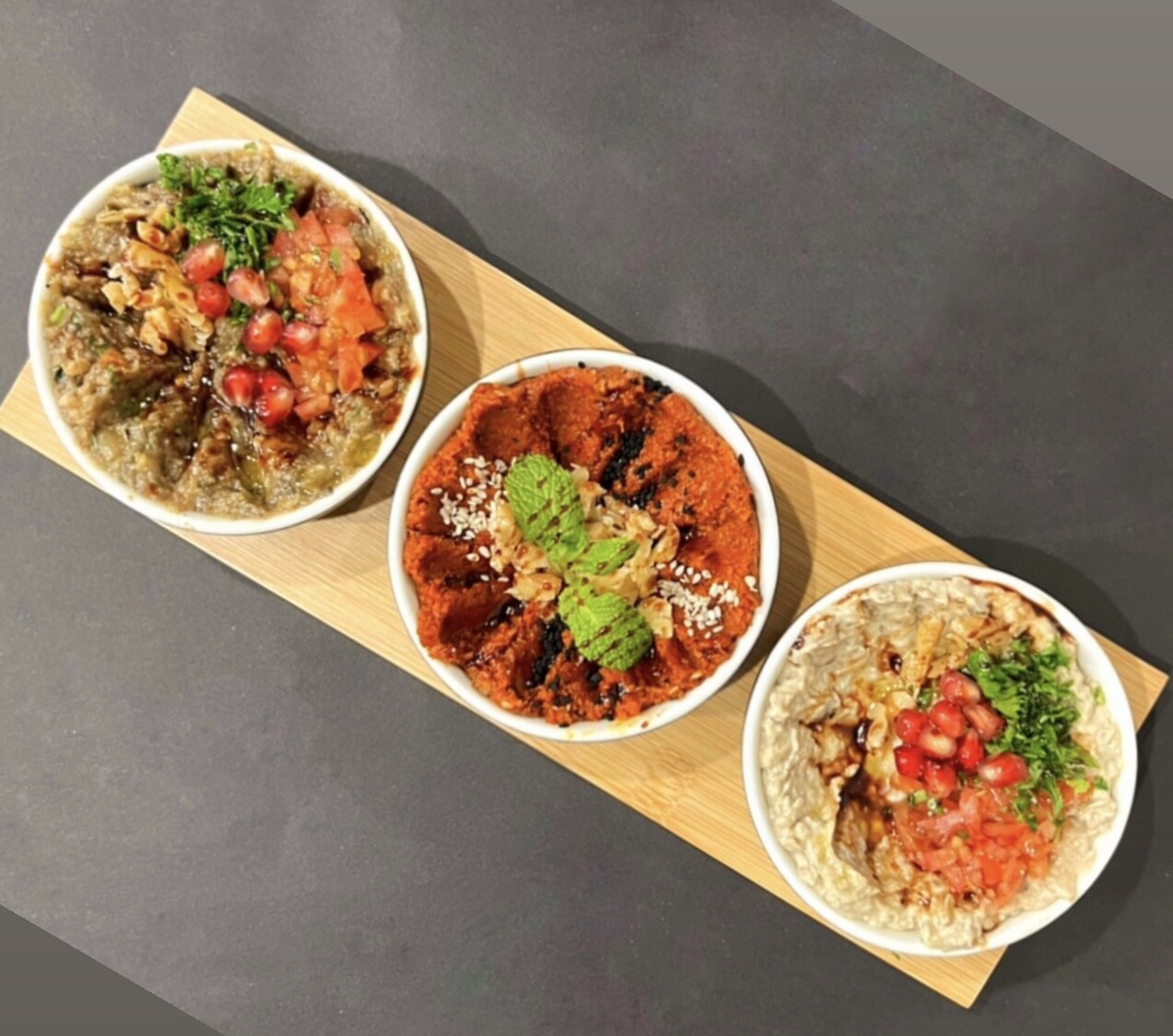 Wooden board with three round appetizer plates.