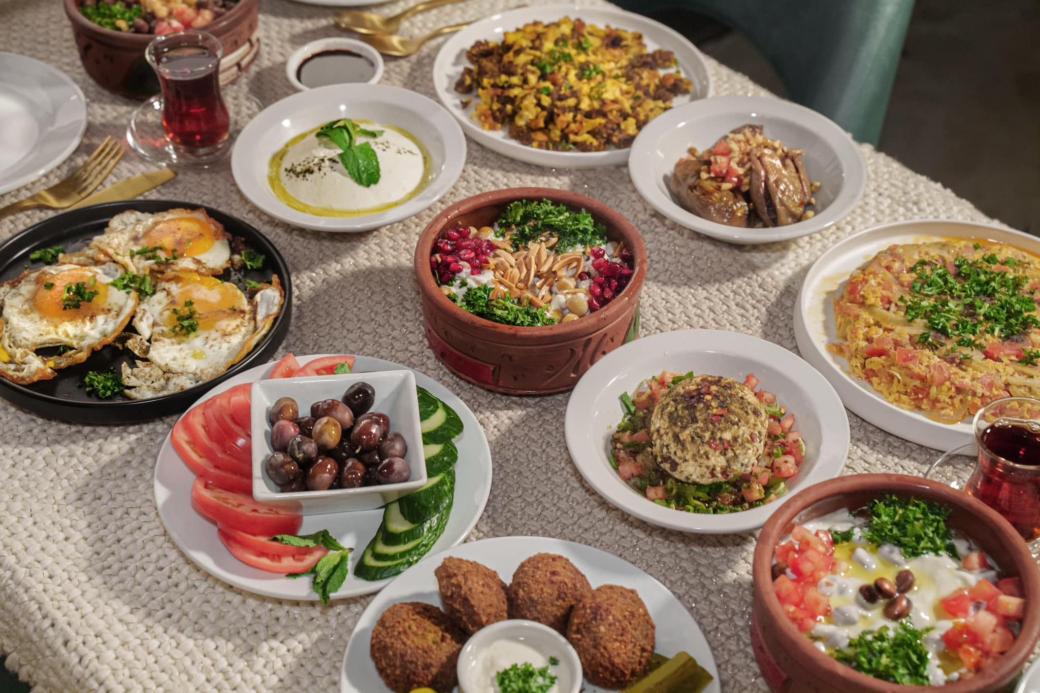 Arabic breakfast table of falafel, hummus, olives and fresh vegetables