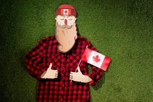 cardboard man in plaid shirt holding canadian flag and showing t.