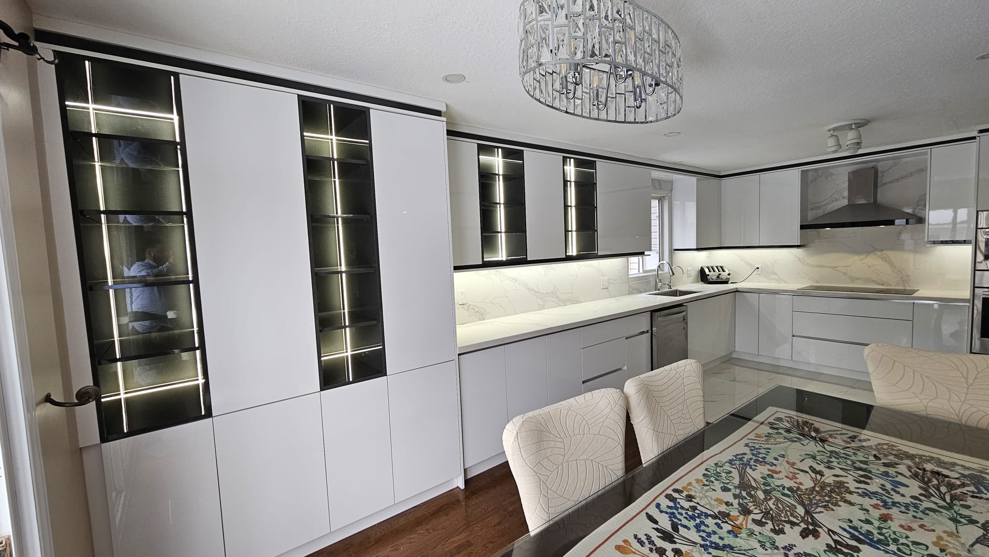 Modern and contemporary kitchen with dining table and glossy white cabinets